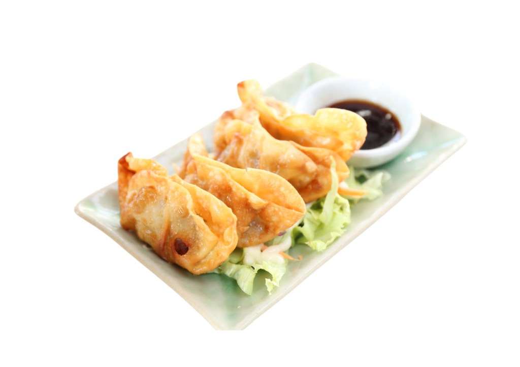 Quatre Gyoza frits disposés sur une assiette blanche avec de la sauce soja. Une photo pour tout savoir sur les Gyoza avec la Japanese Cuisine Academy.