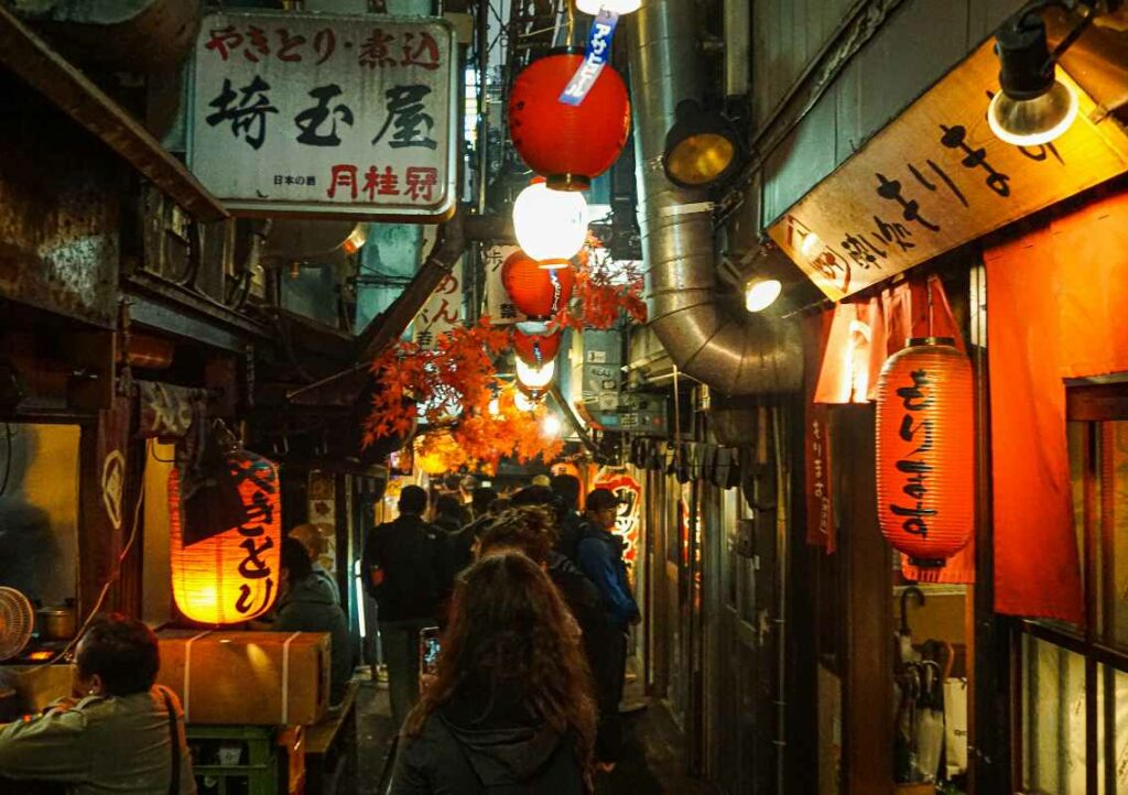 Une rue au Japon avec des restaurants et des enseignes lumineuses.